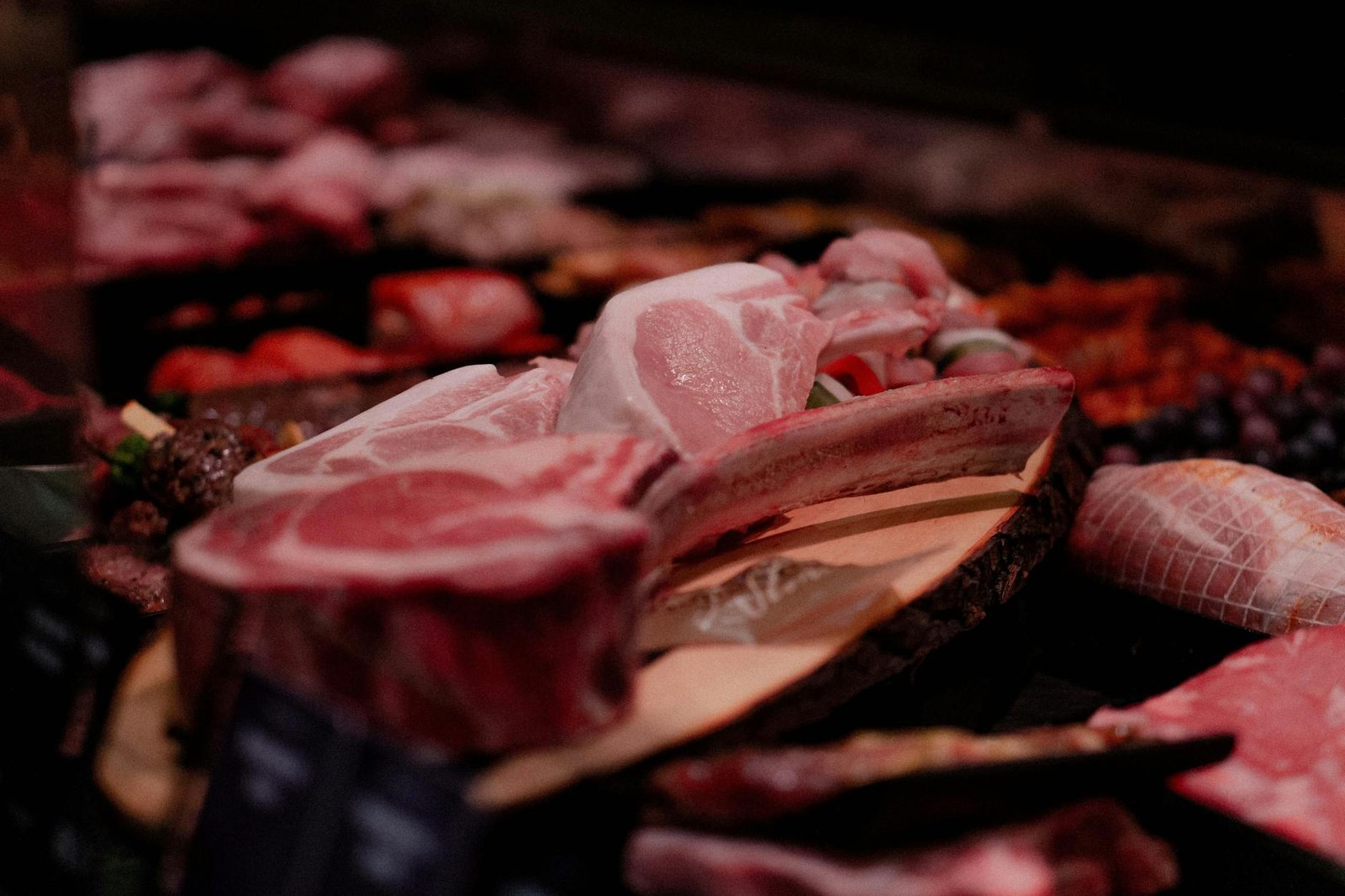 Tagli di carne fresca su bancone di macelleria con etichette di tracciabilità