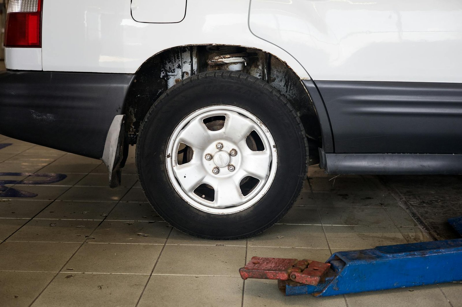Meccanico monta un cerchio in lega su un'auto in officina