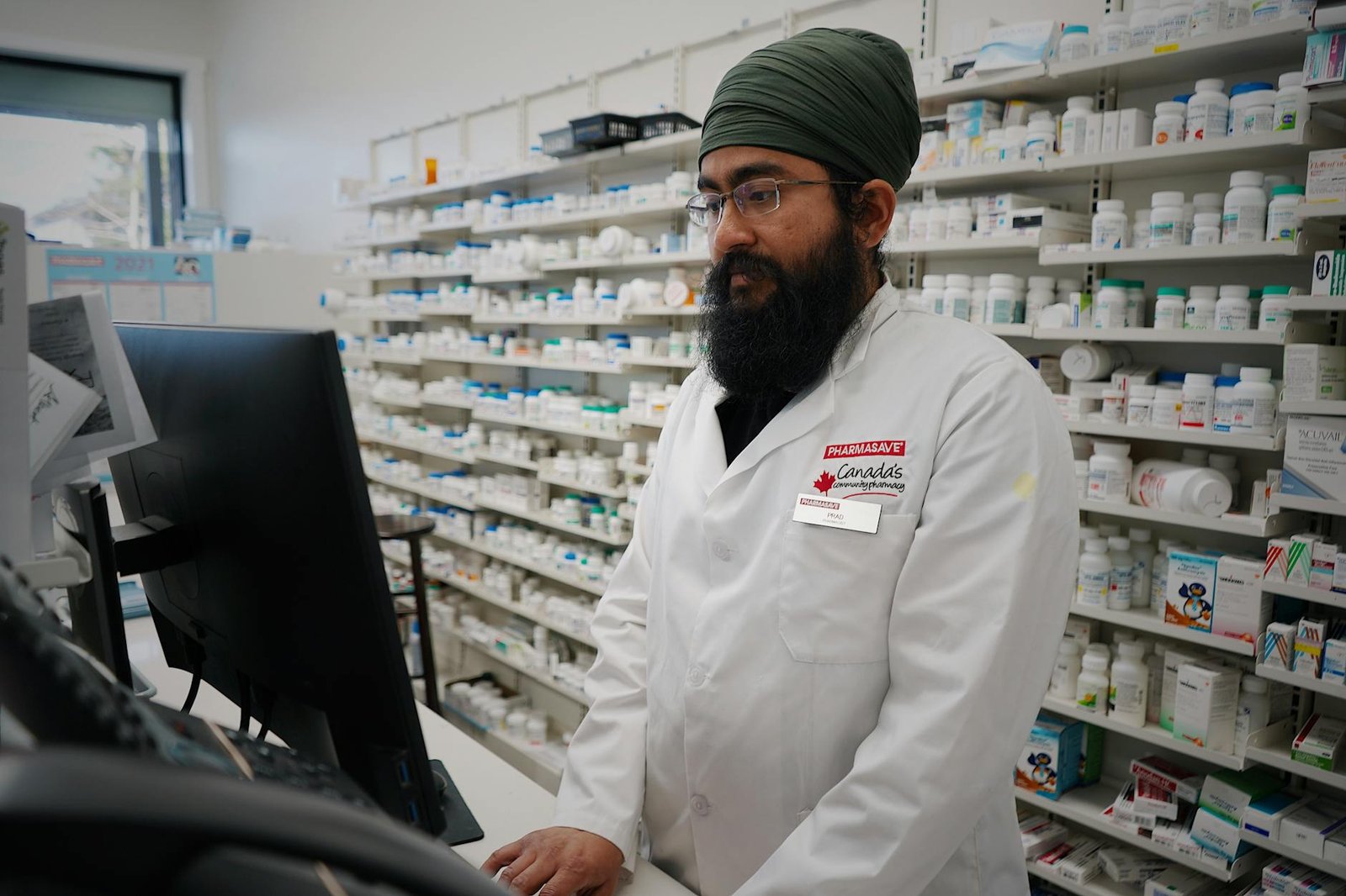 Farmacista tra gli scaffali di medicinali e prodotti per la salute