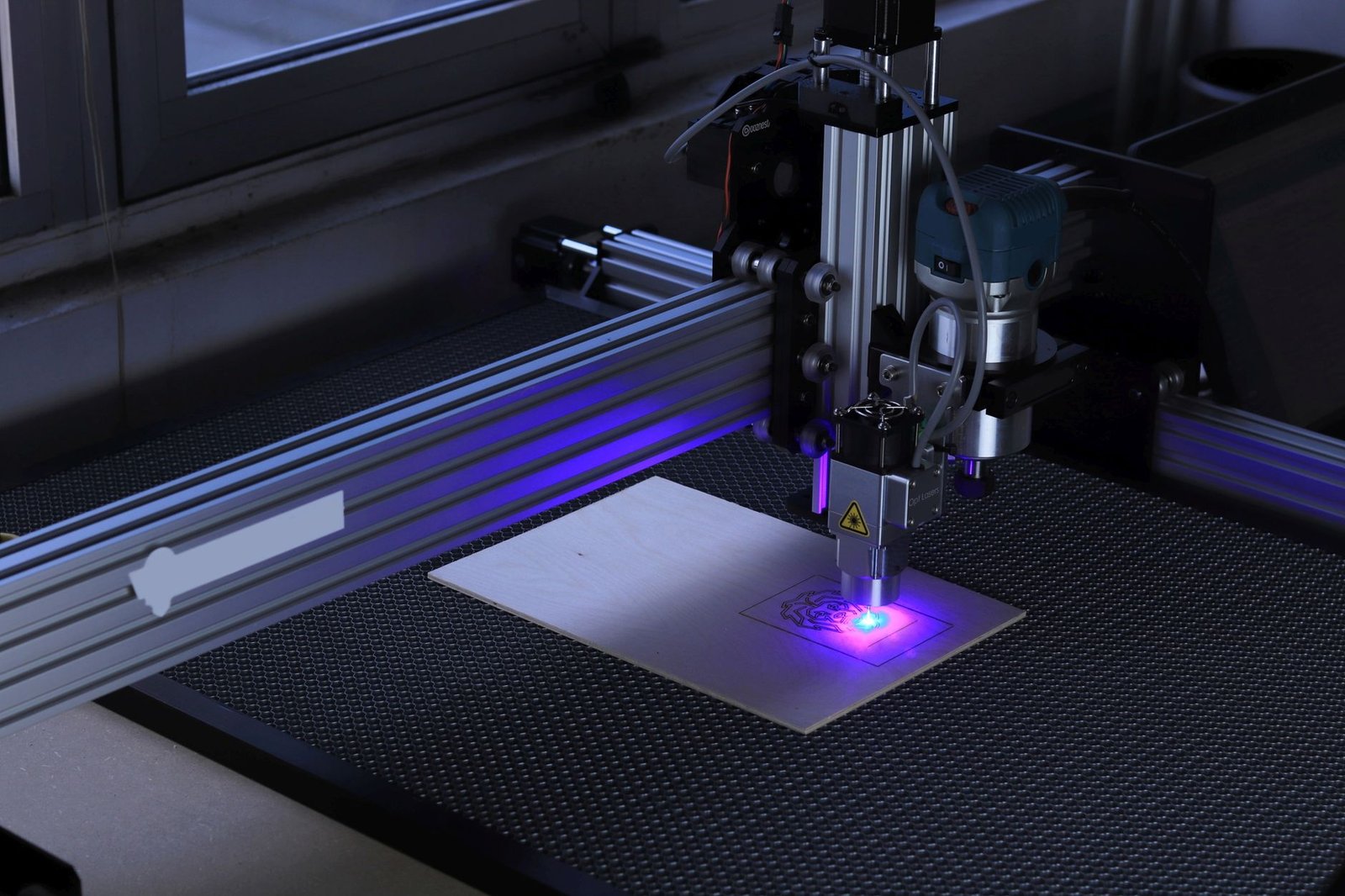 Incisore laser da tavolo al lavoro su una tavoletta di legno