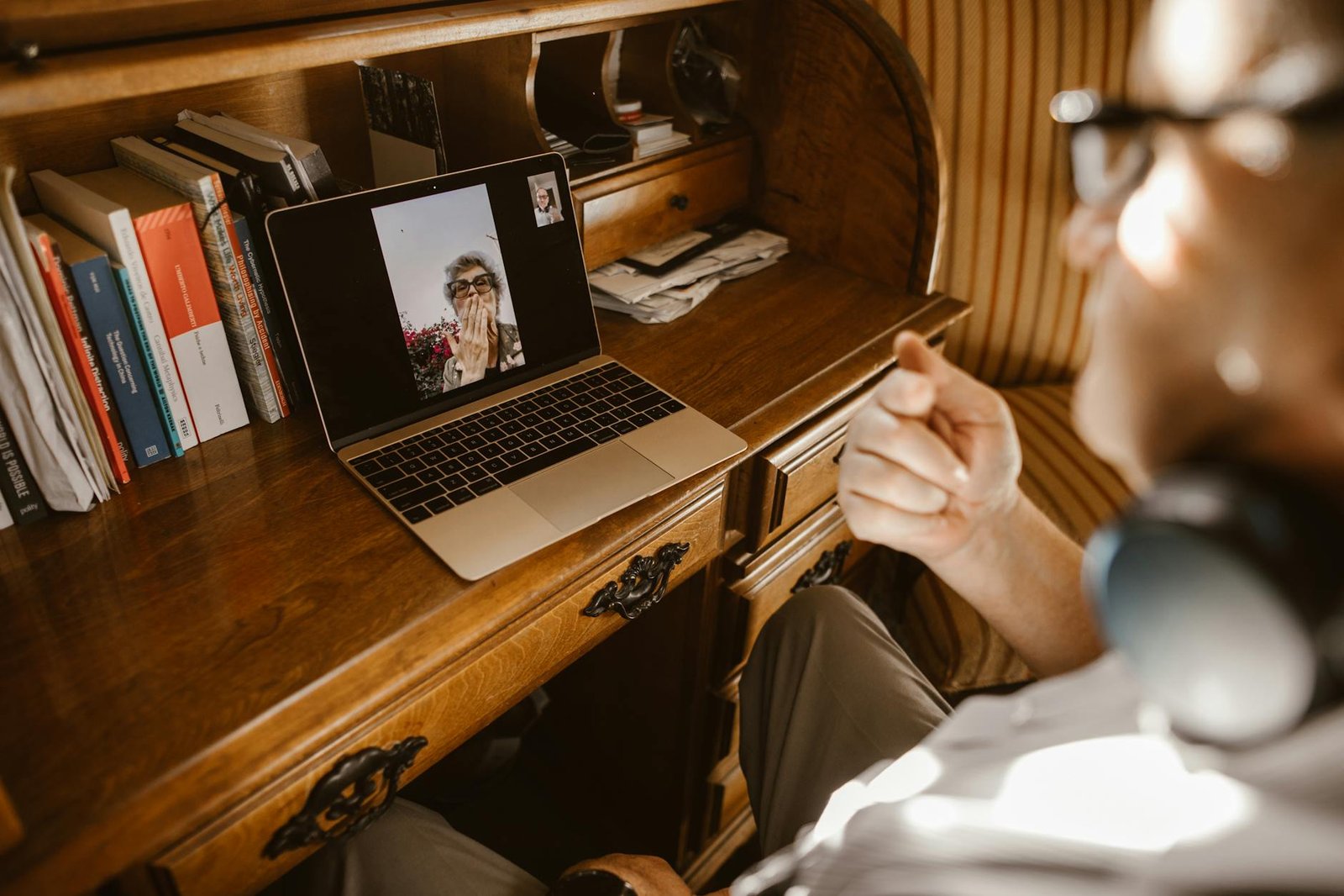 Persona davanti al computer durante una videochiamata da casa con cuffie