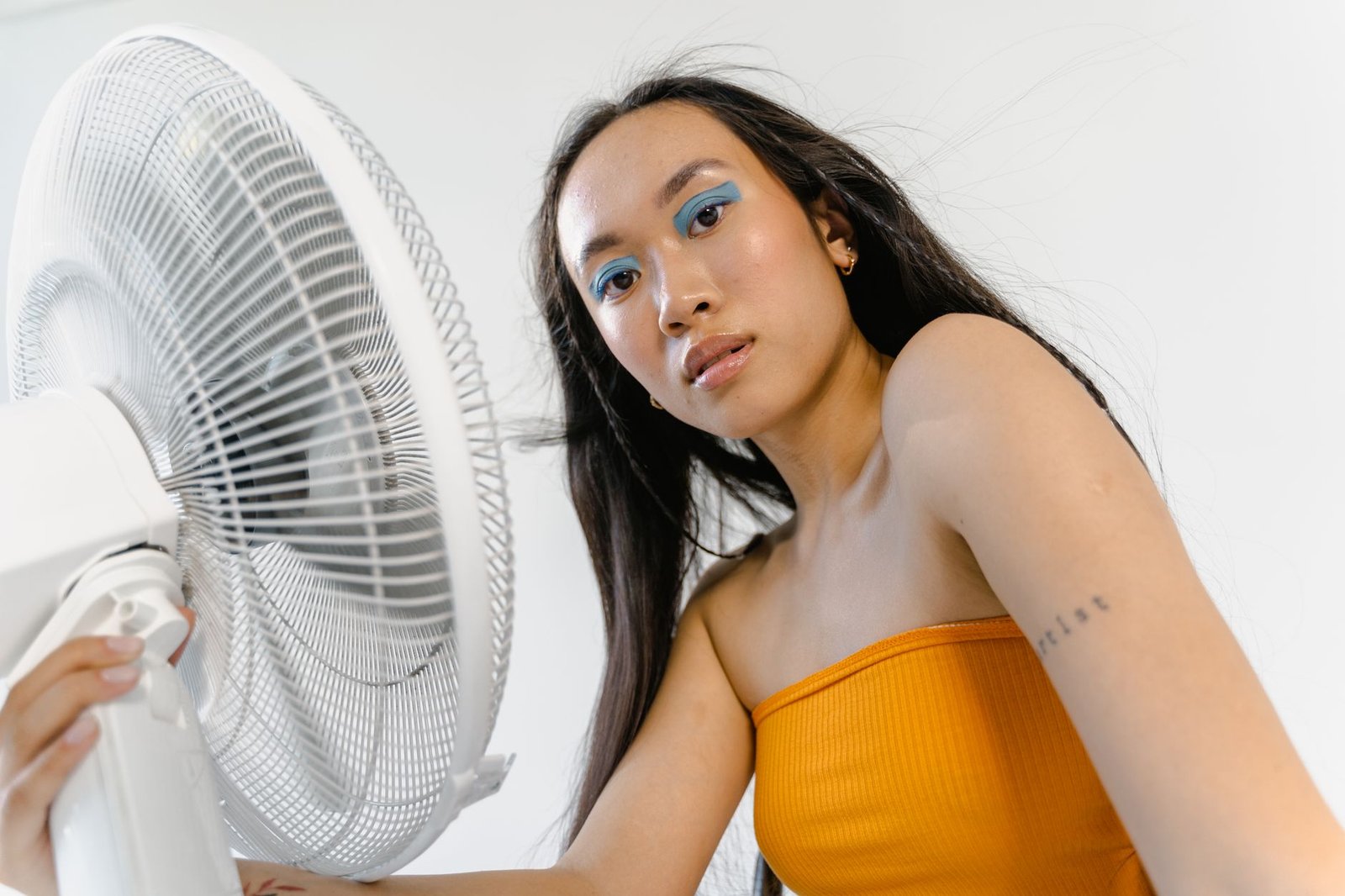 Persona si rinfresca davanti a un ventilatore durante una giornata calda